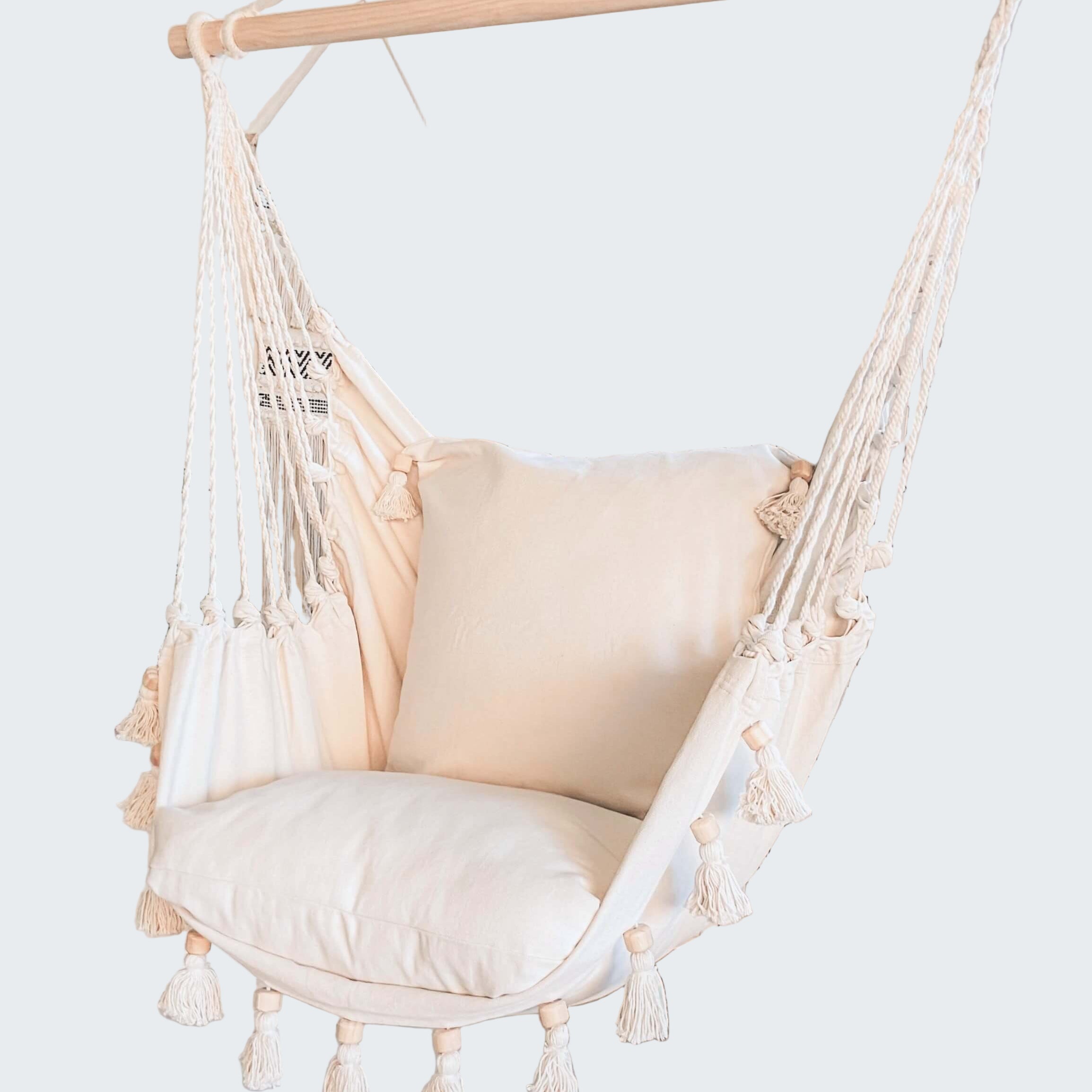 White hammock chair with tassels in a room with decorative elements