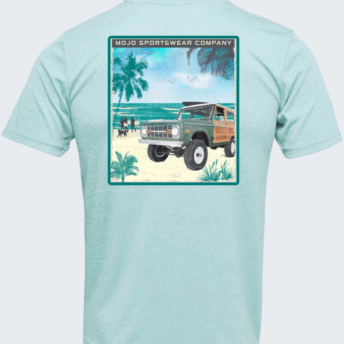 Light blue t-shirt with a graphic of a beach scene and vintage truck on a white background