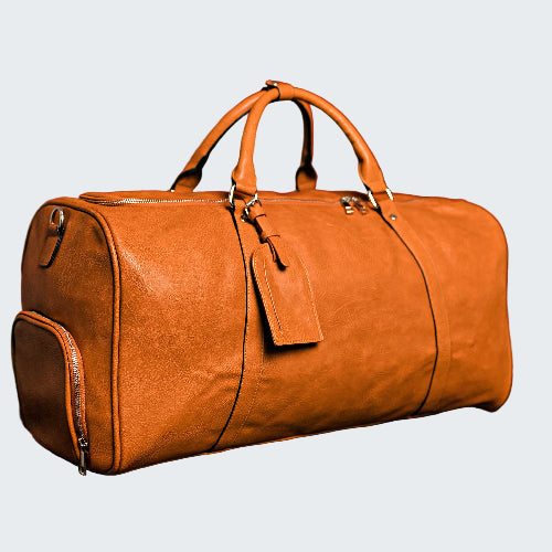 Brown leather duffel bag on a reflective surface with a red background