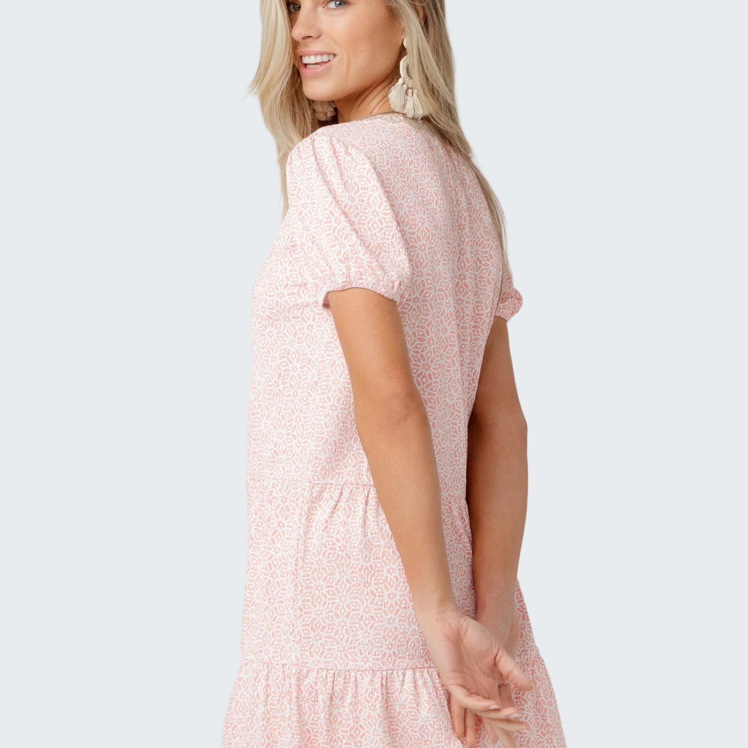 Woman wearing a pink dress with a white background