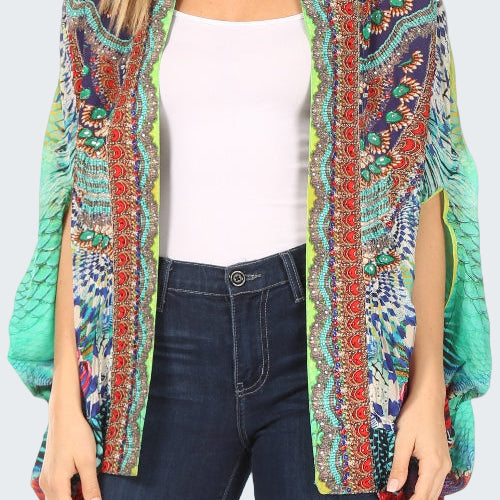 Woman wearing a colorful patterned kimono over a white top and dark jeans.