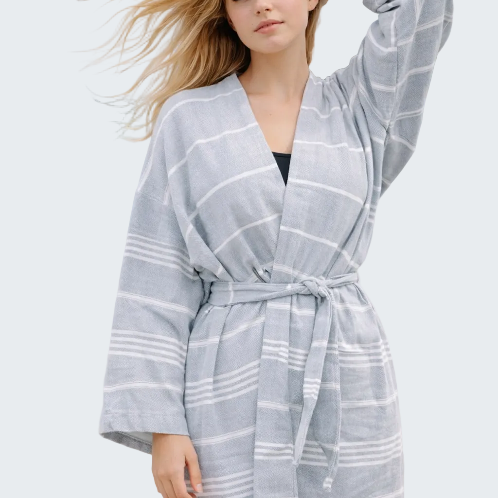 Woman wearing a gray and white checkered robe on a beach