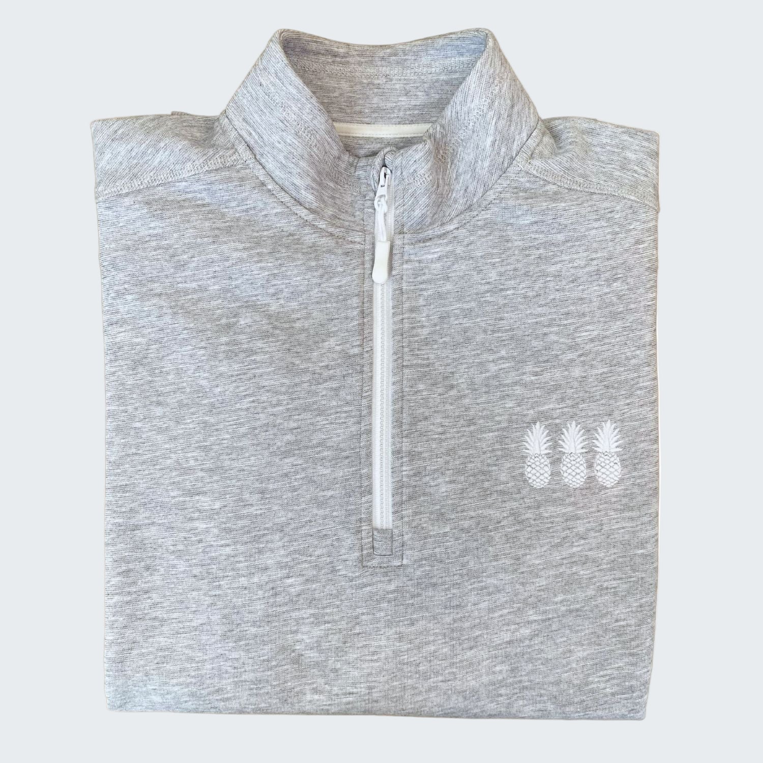 Folded gray pullover with a white zipper and three pineapples logo on a white background