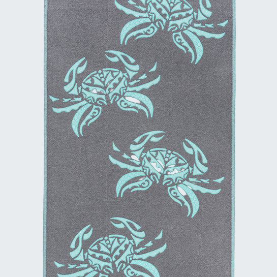 Gray towel with teal crab patterns on a white background