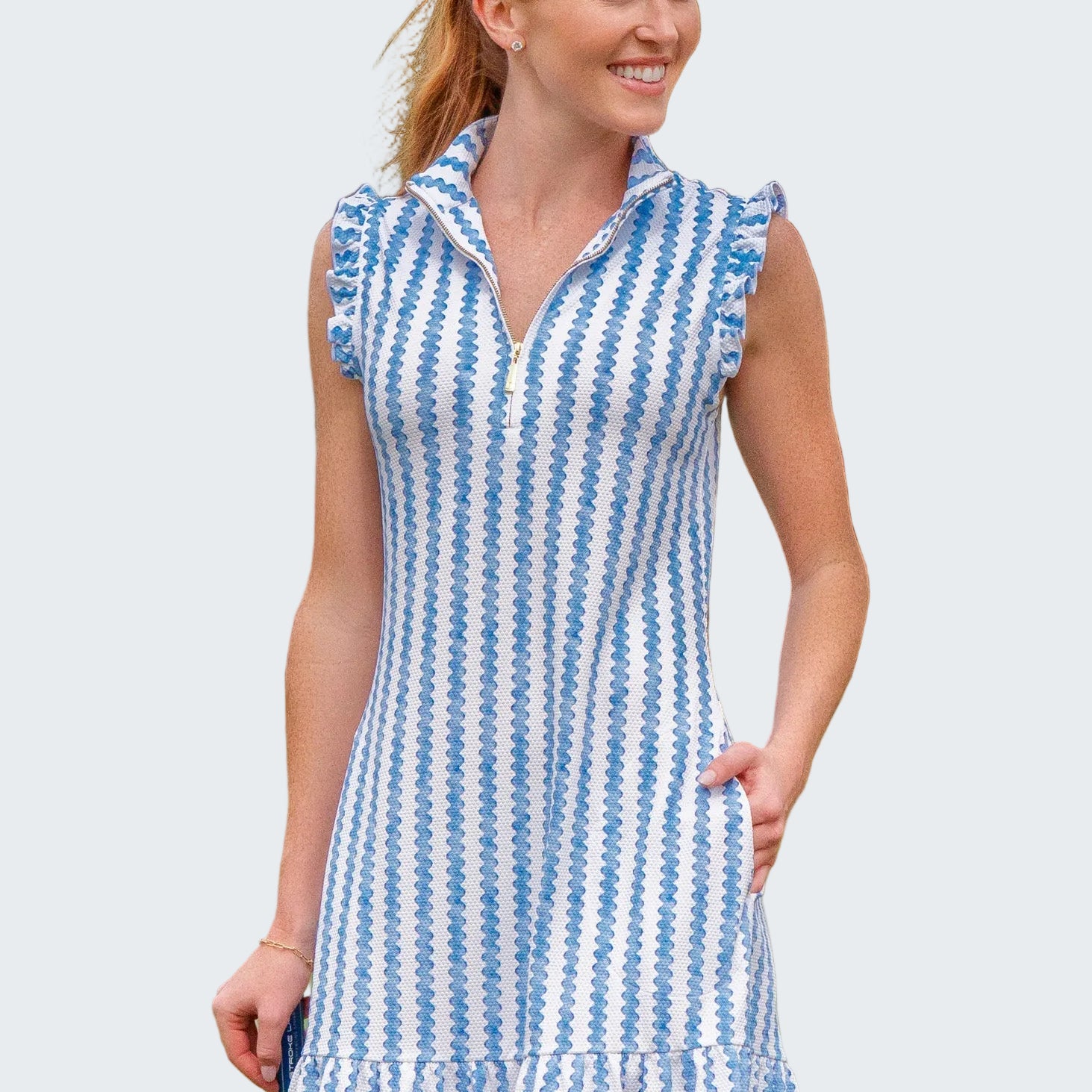 Woman wearing a blue and white striped dress on a golf course