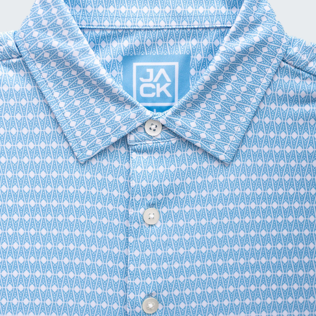 Close-up of a blue patterned shirt with a brand label on a white background