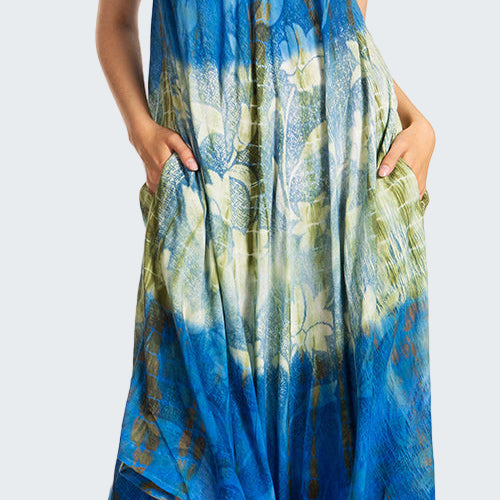 Blue and green patterned dress worn by a model on a white background