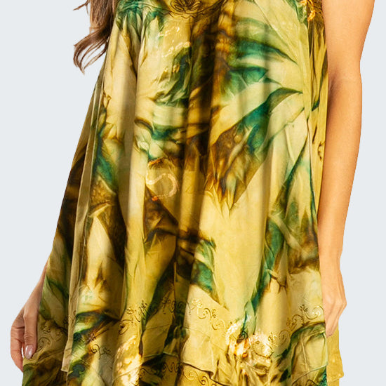Woman wearing a yellow and green floral dress on a white background