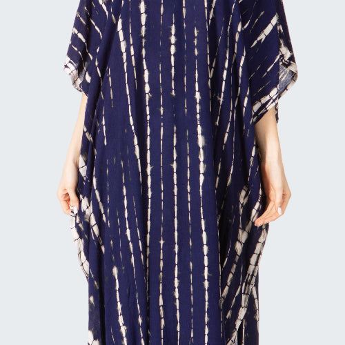 Woman wearing a navy blue tie-dye dress on a white background