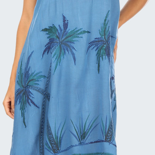 Blue dress with palm tree pattern worn by a model on a white background