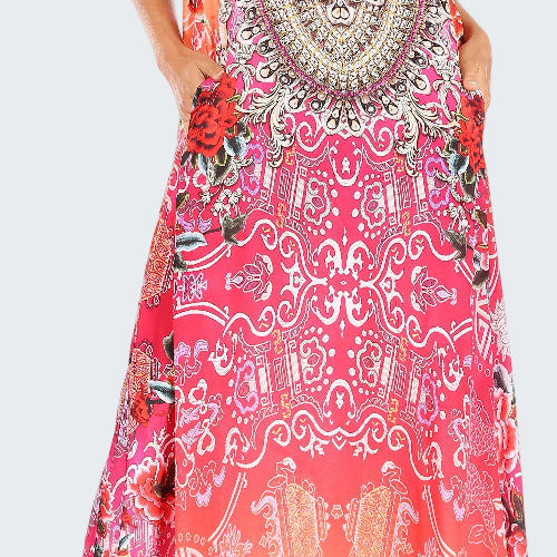 Woman wearing a colorful patterned maxi dress on a white background