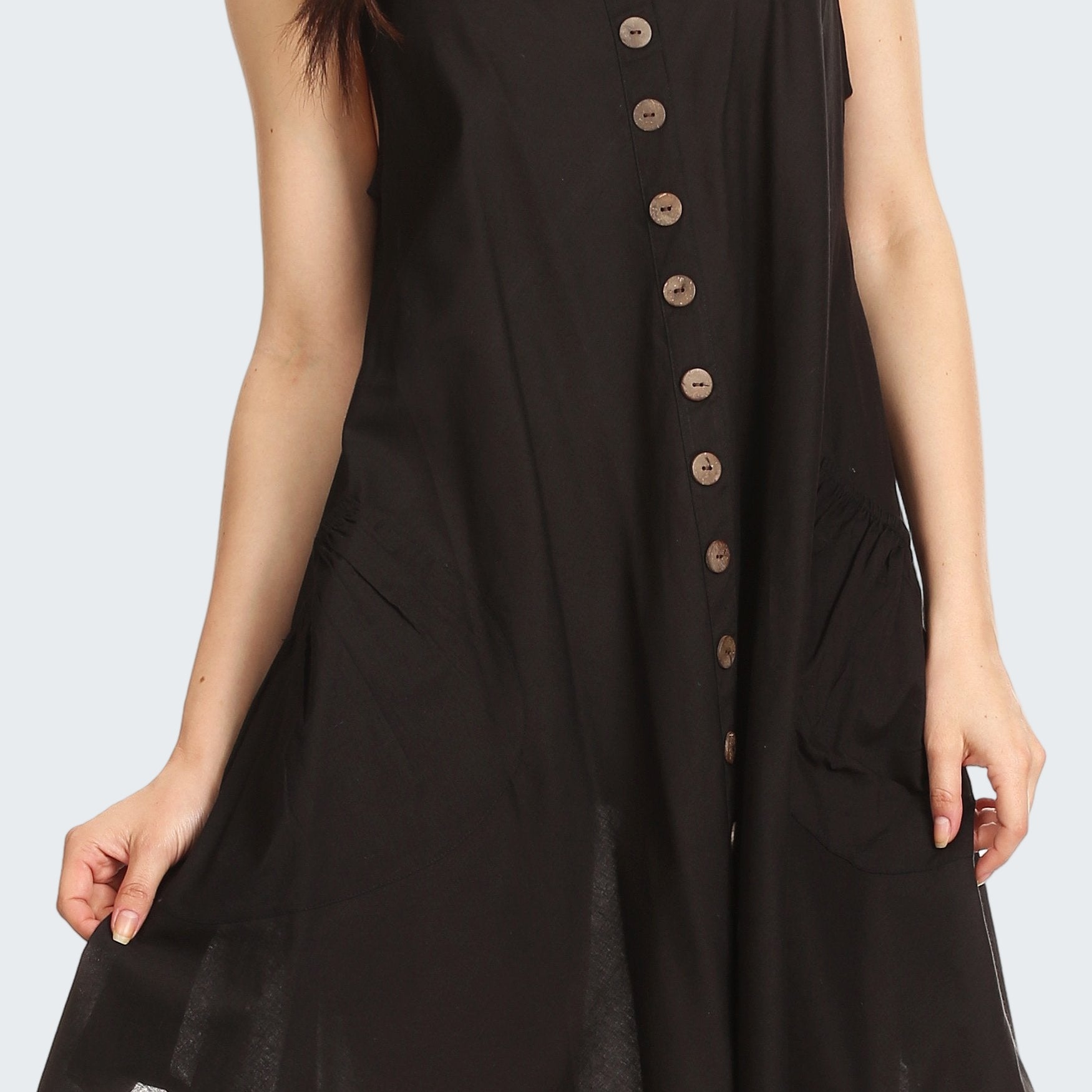 Black sleeveless dress with buttons on a white background