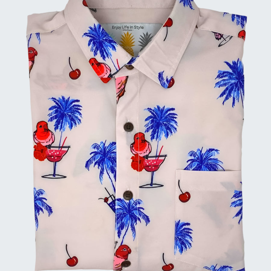 Shirt with tropical pattern featuring palm trees, cherries, and cocktails on a white background