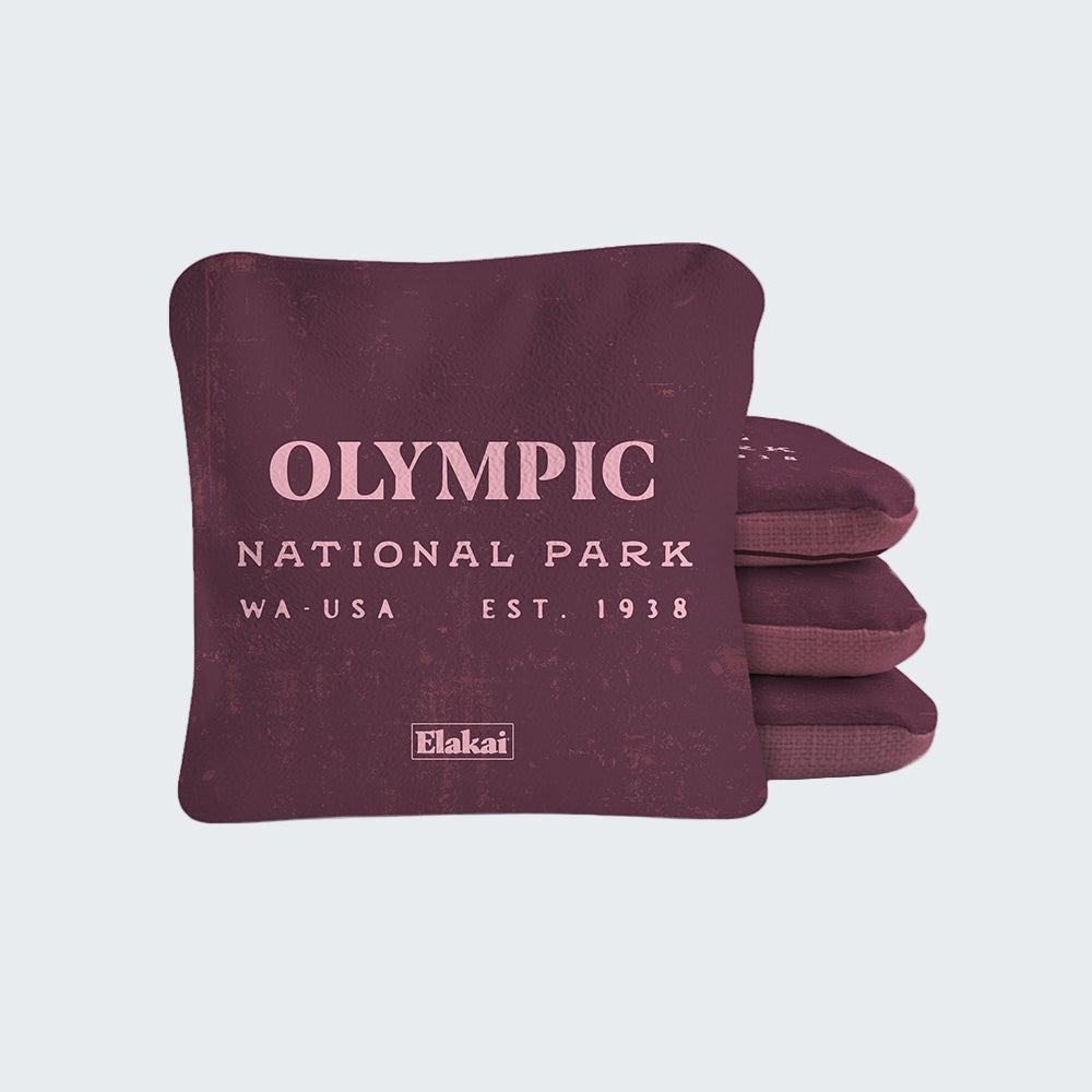 Maroon pillow with 'Olympic National Park' text and Elakai logo on a white background