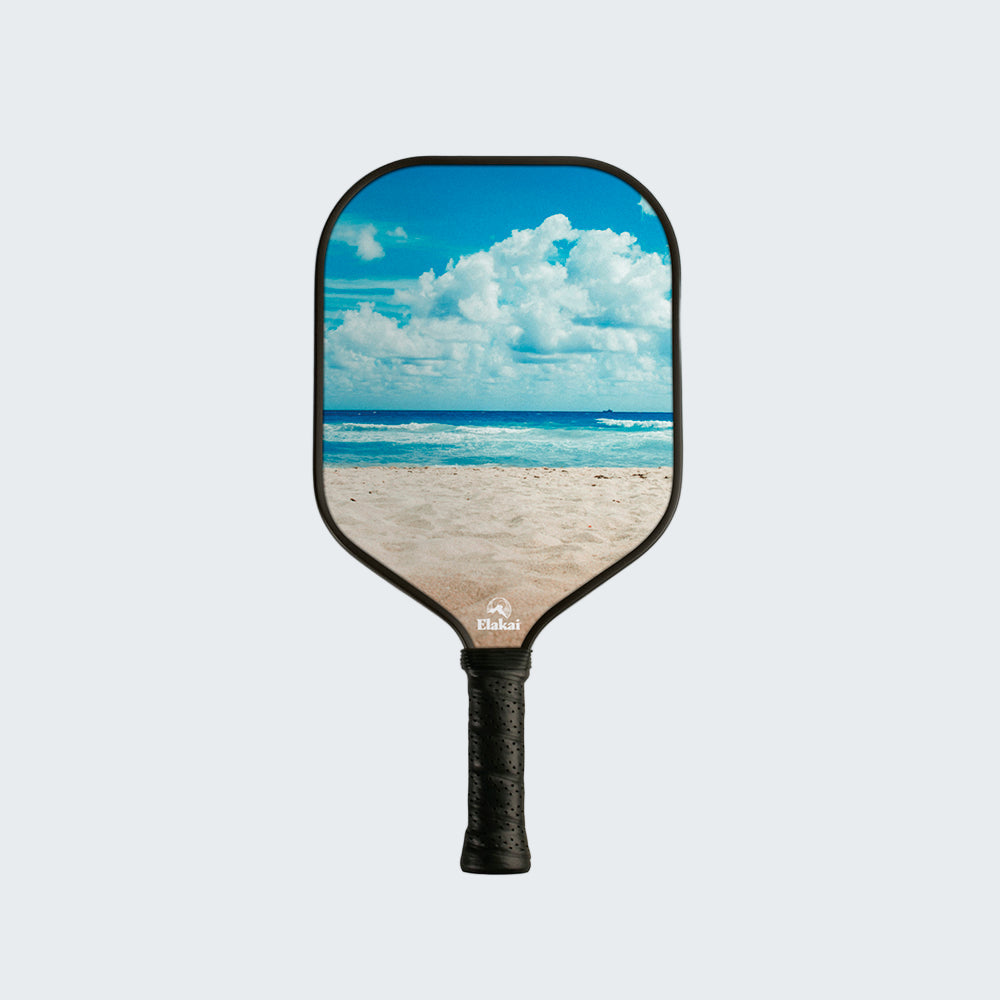 Pickleball paddle with beach and sky design on a white background