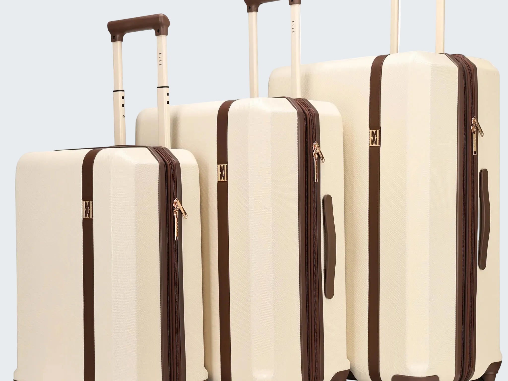 Set of three cream-colored suitcases with brown accents on a white background