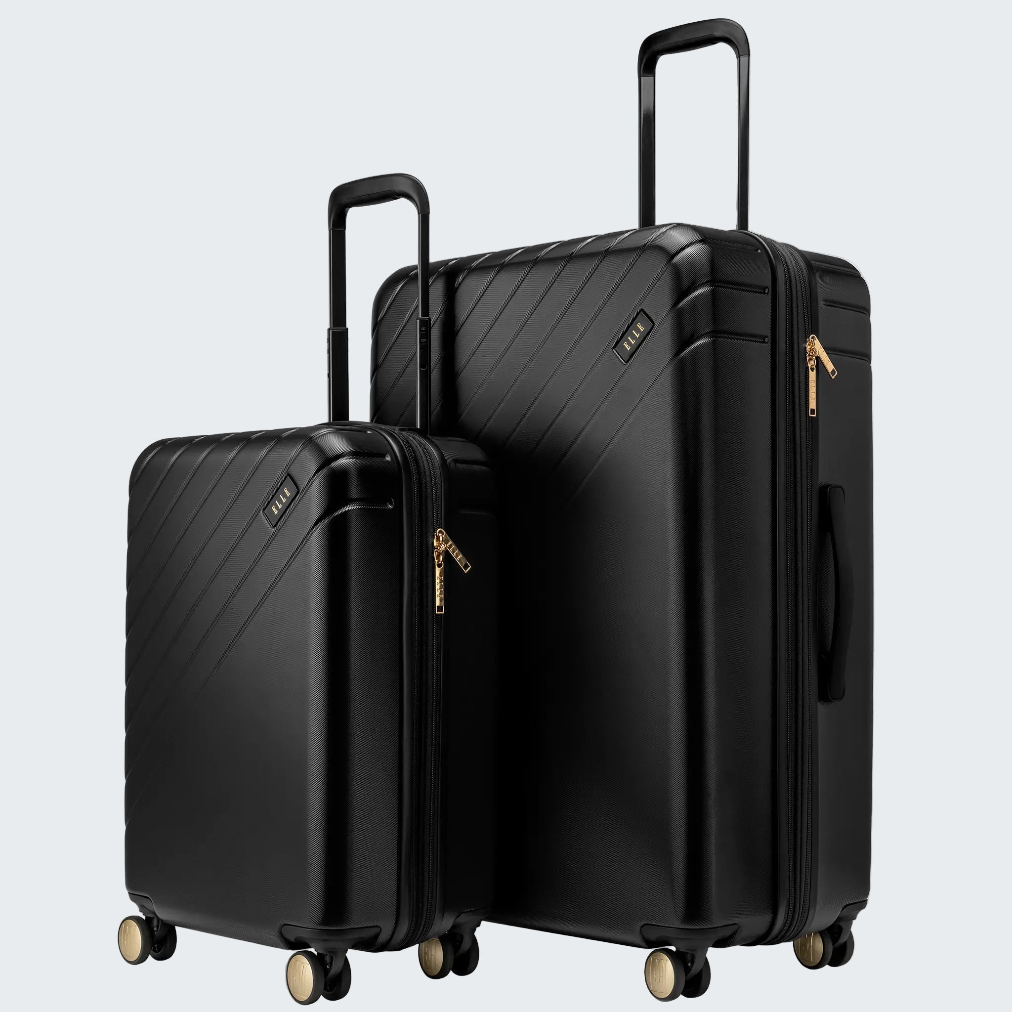 Two black suitcases with gold zippers on a white background