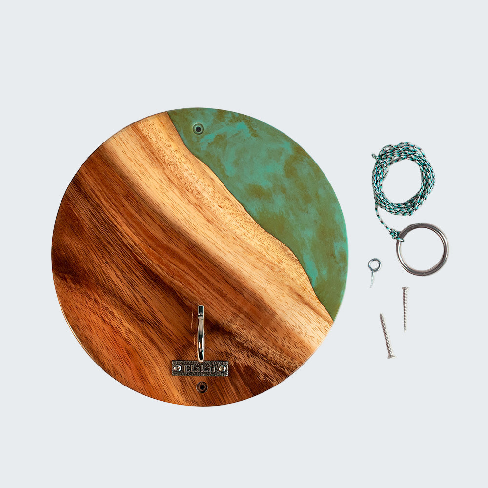 Round wooden and teal wall hook with keys and a bracelet on a white background