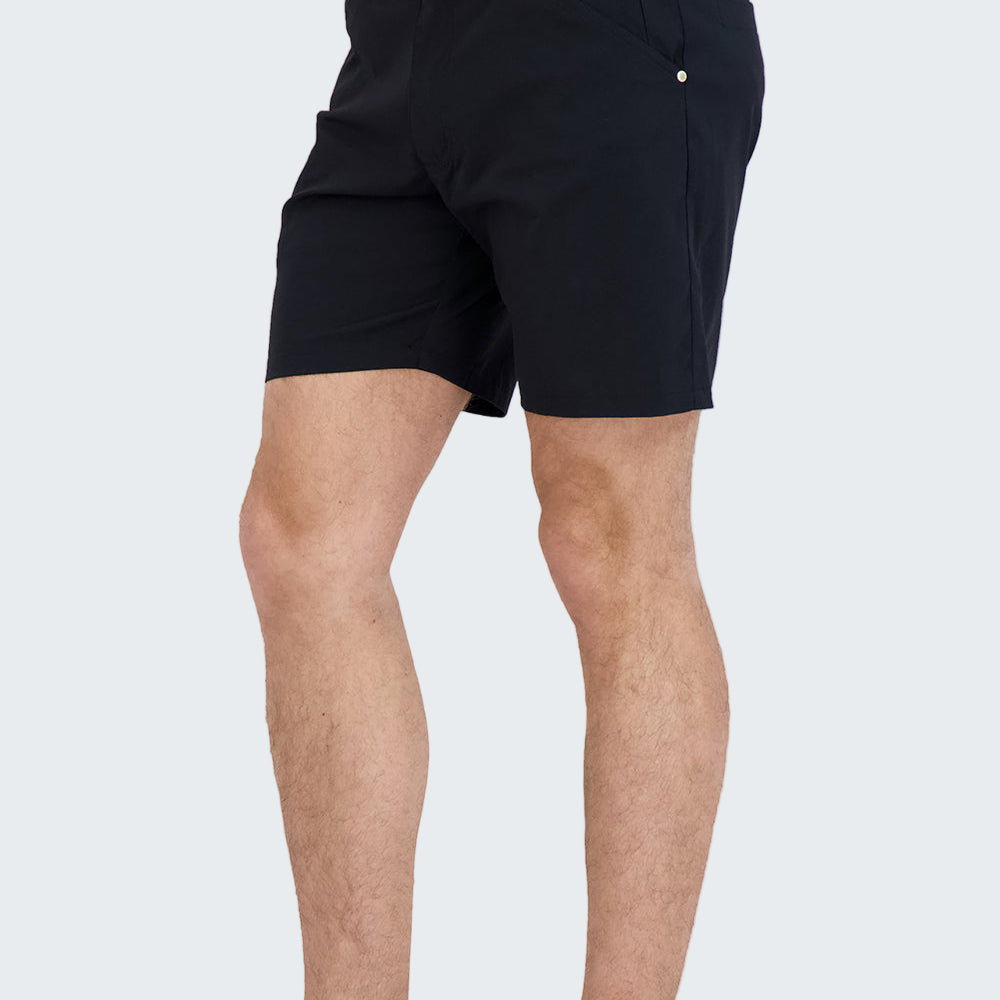 Person wearing black shorts and black high-top sneakers on a white background