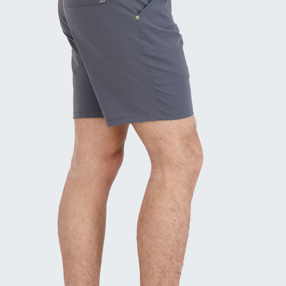 Person wearing gray shorts and black sneakers on a white background