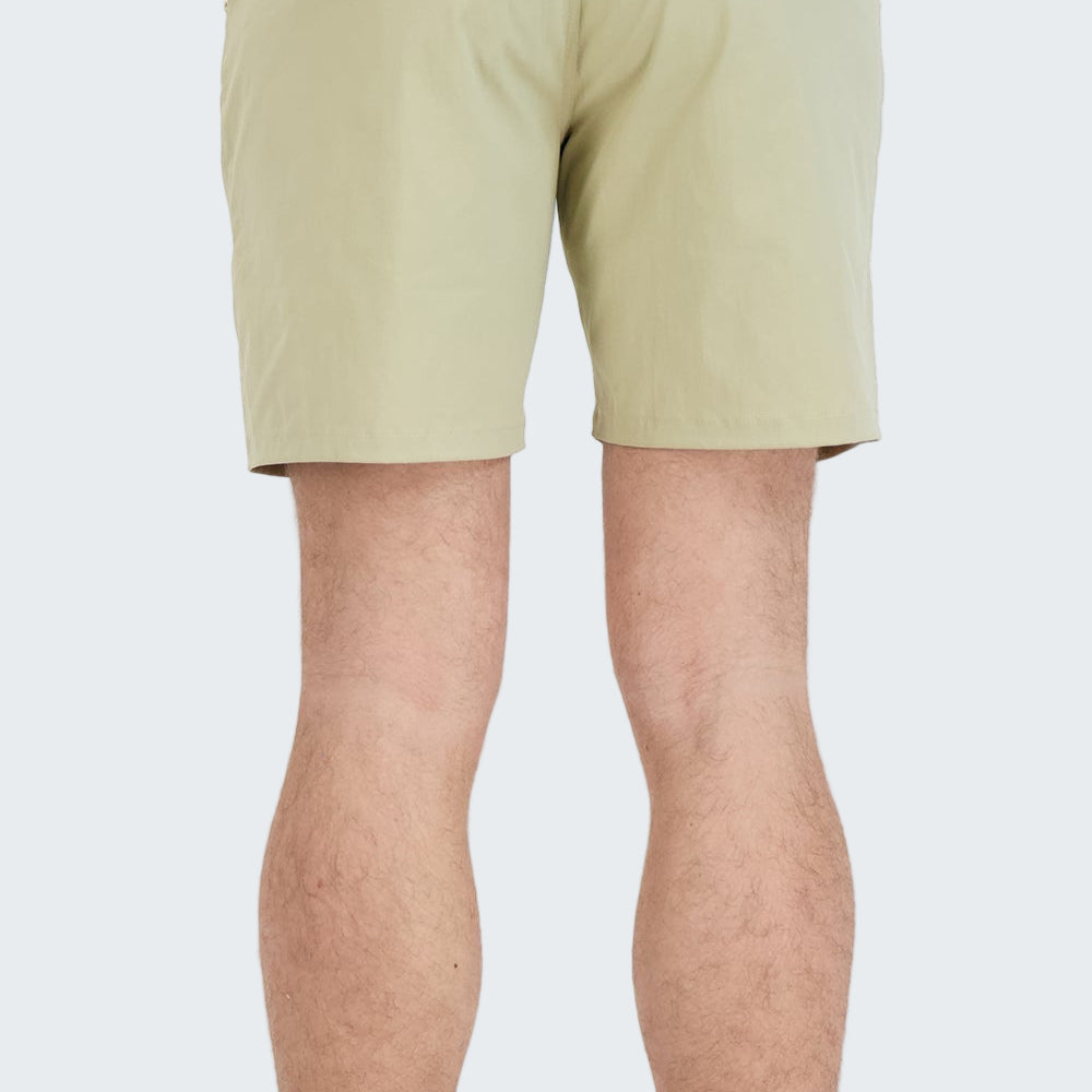 Beige shorts worn by a person on a white background