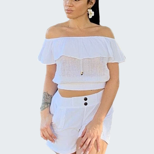Woman wearing a white off-shoulder top and shorts in an outdoor setting