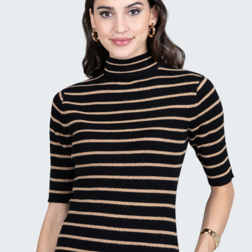 Woman wearing a black and beige striped turtleneck sweater on a gray background