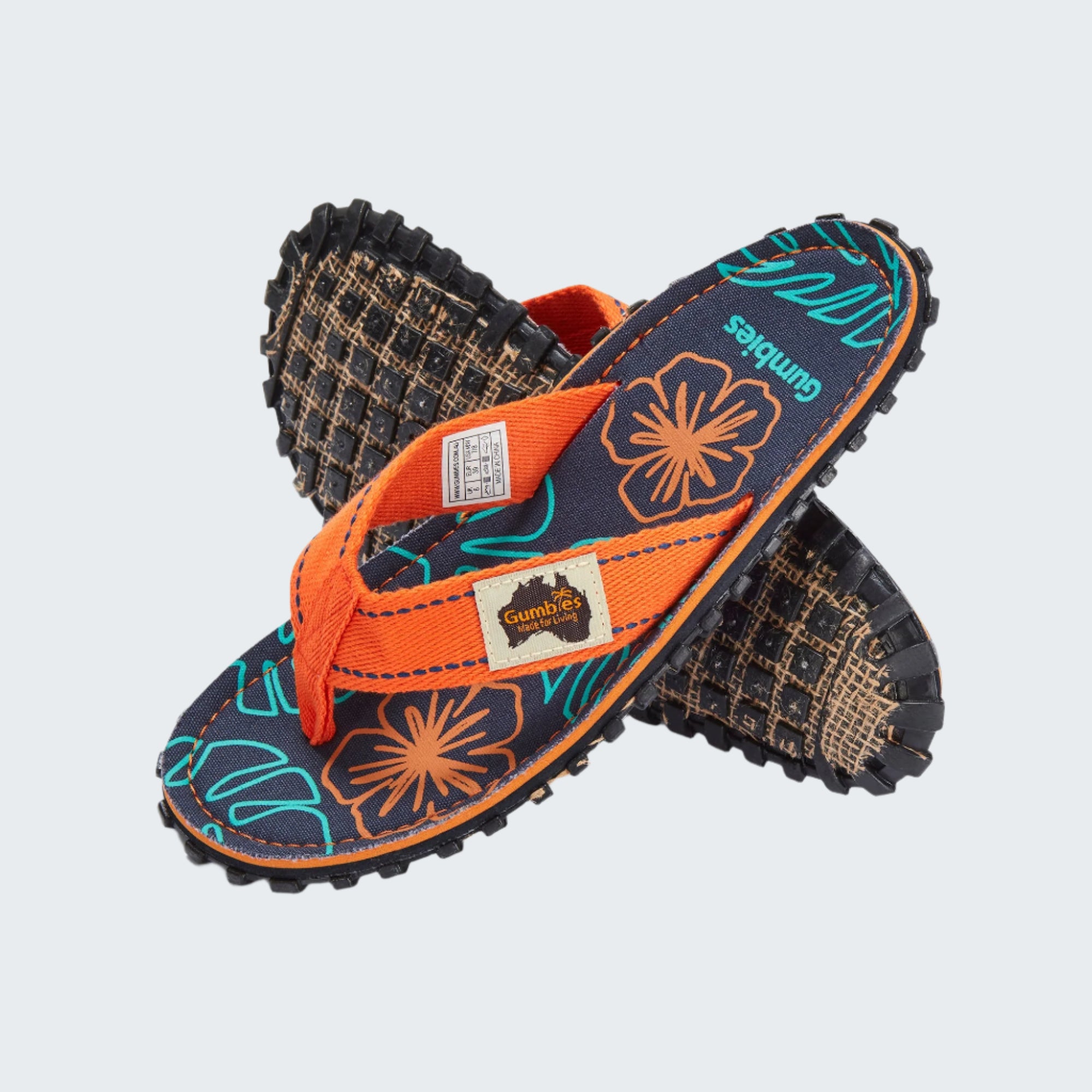 Pair of sandals with orange straps and floral patterns on a white background