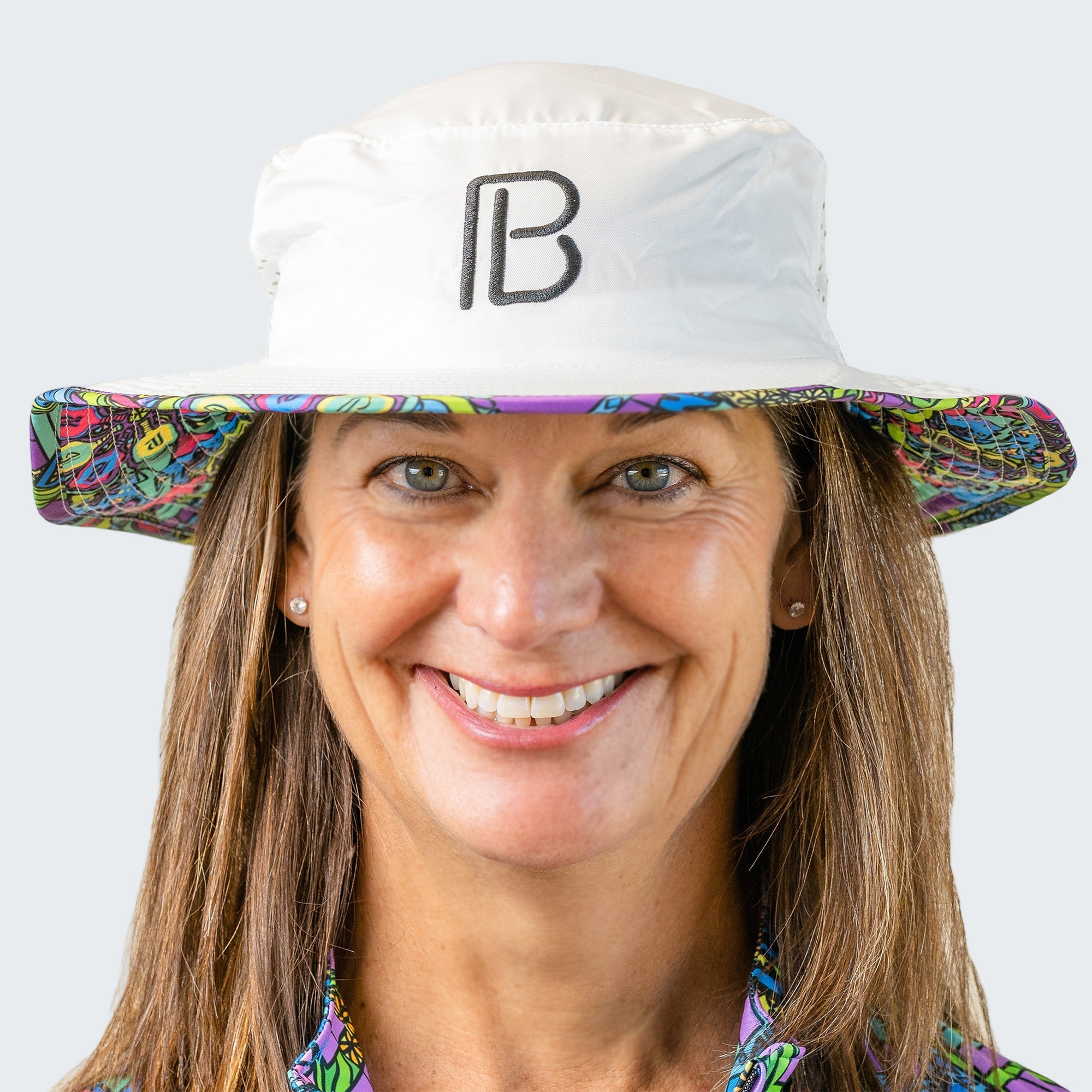 Person wearing a white bucket hat with colorful brim and 'PB' logo on a light blue background