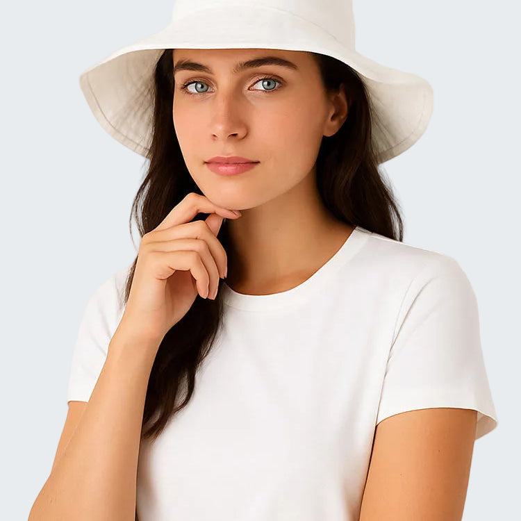 Woman wearing a white hat and white shirt against a light background