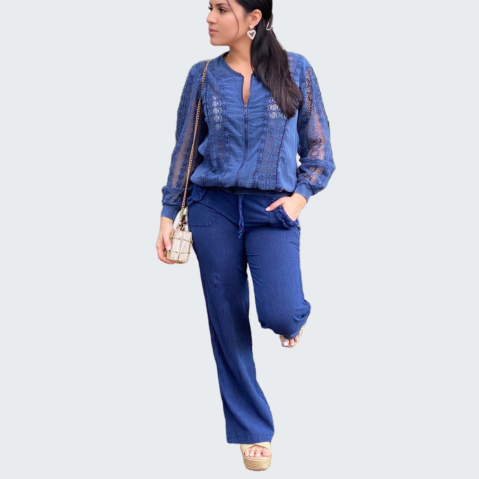 Woman in a blue outfit standing in a forest setting