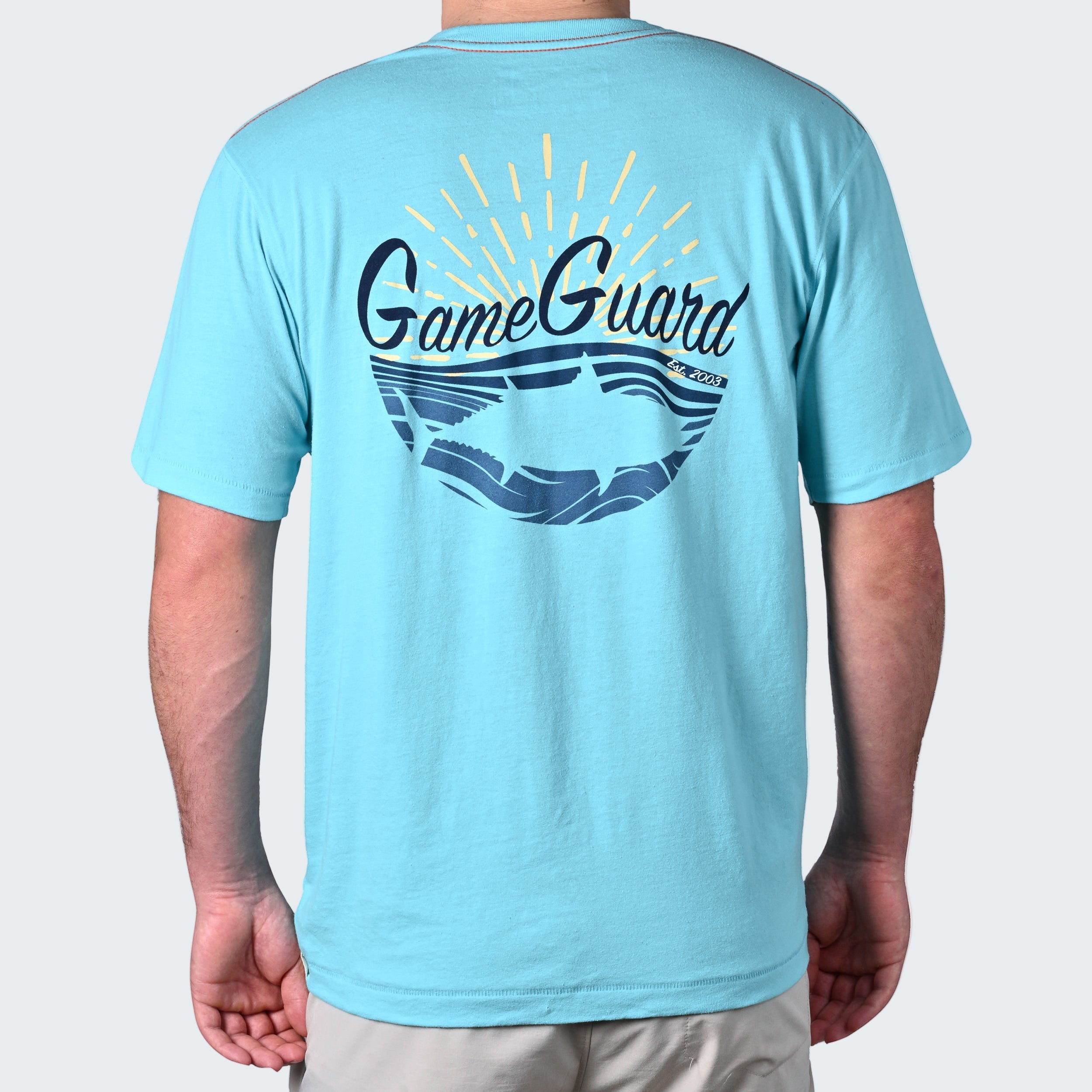 Light blue t-shirt with 'GameGuard' logo on the back, worn by a person.