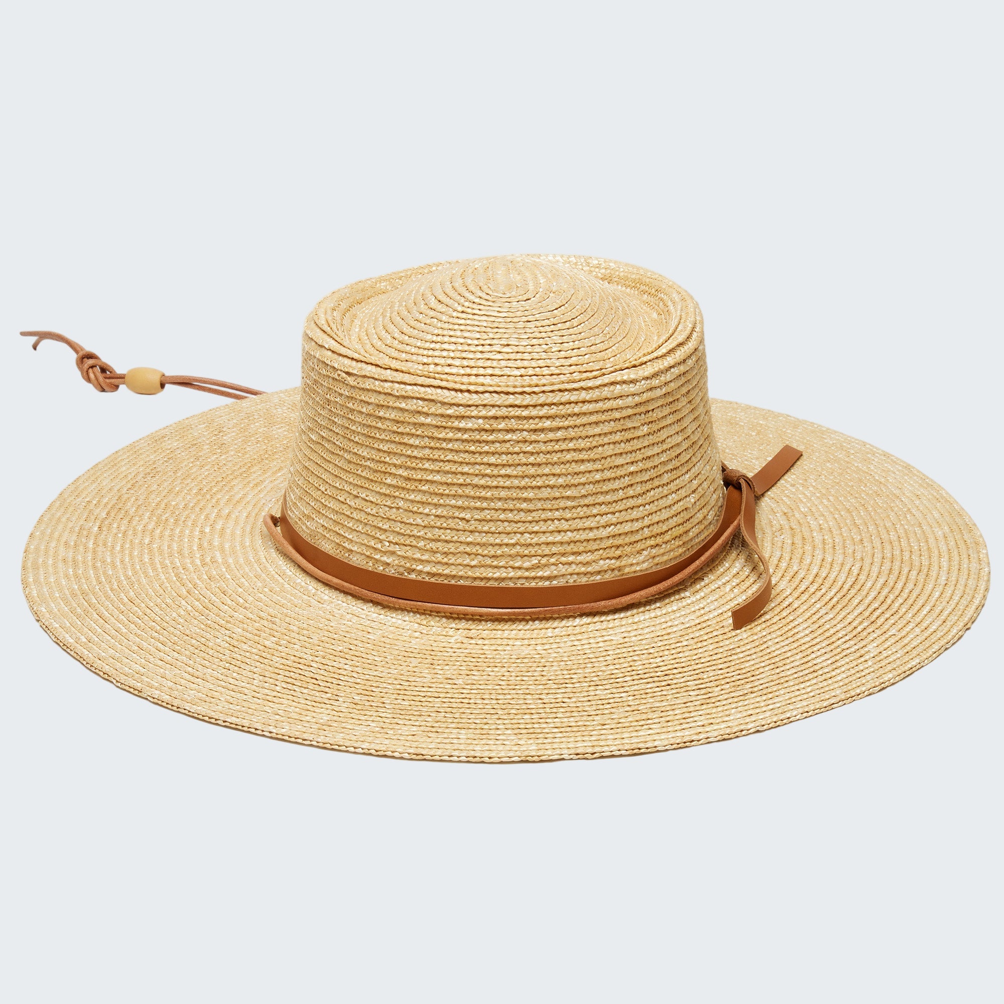 Beige straw hat with a brown band on a white background