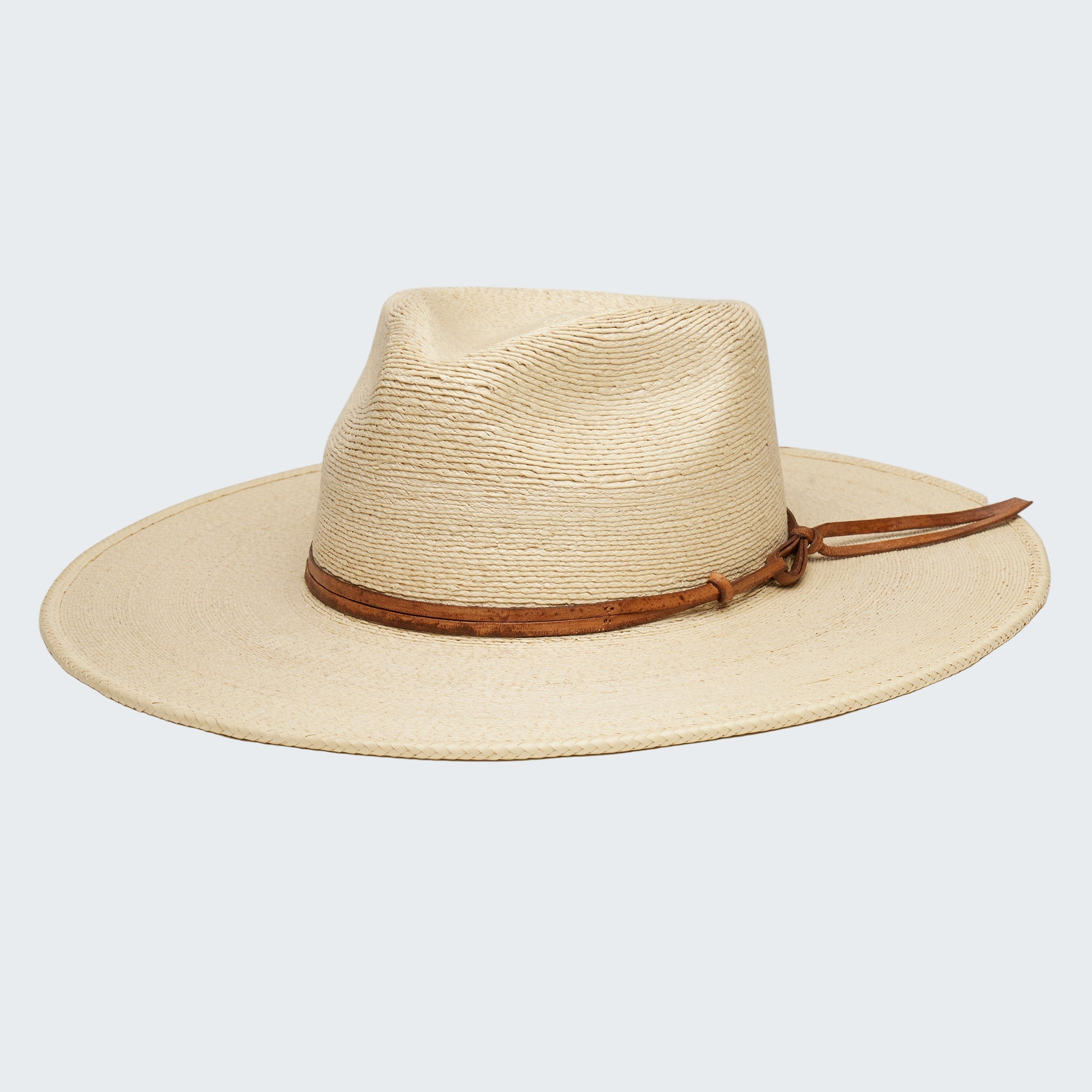 Beige straw hat with a brown leather band on a white background