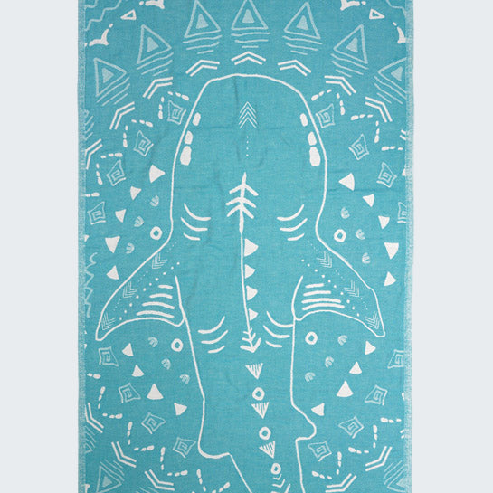 Teal towel with white shark design and geometric patterns on a white background