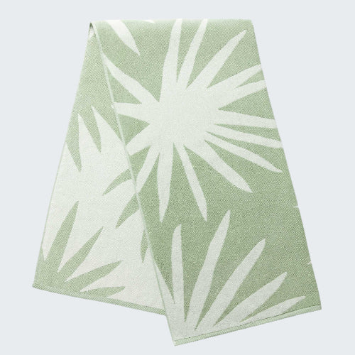Two green and white patterned napkins on a light gray background