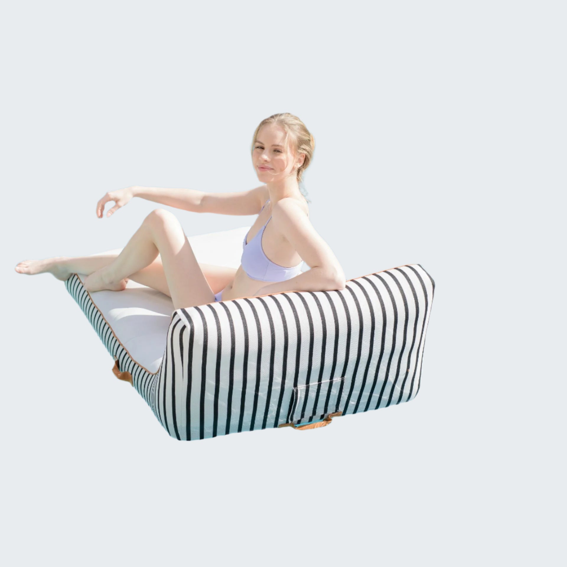 Woman sitting on a striped pool float in a swimming pool