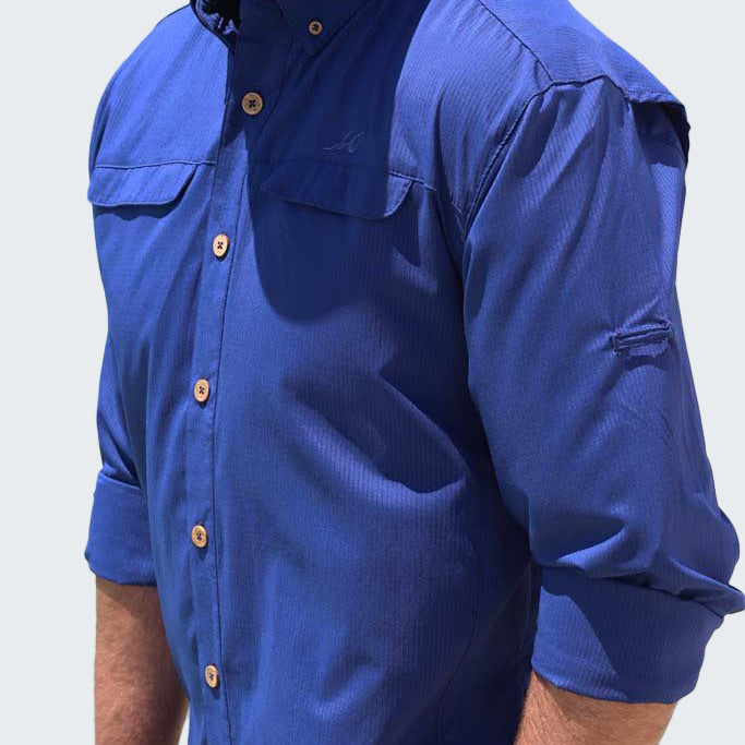 Man wearing a blue shirt with rolled-up sleeves on a white background