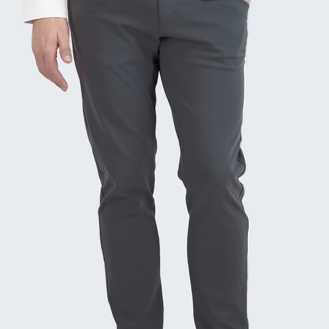 Person wearing gray pants and black sneakers on a white background