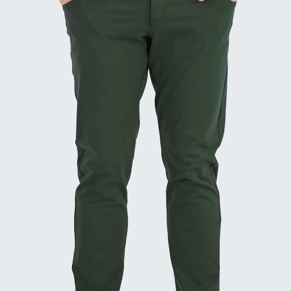 Person wearing green pants with a white shirt and black sneakers on a white background