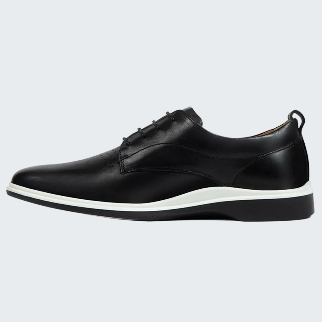 Black leather shoe with white sole on a white background