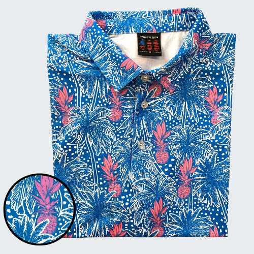 Folded blue tropical pattern shirt with close-up of design on a white background