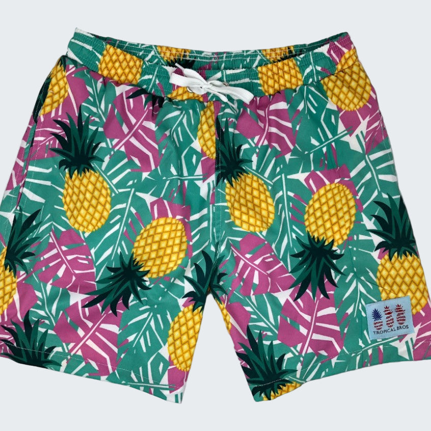 Tropical-themed shorts with pineapple and leaf pattern on a white background