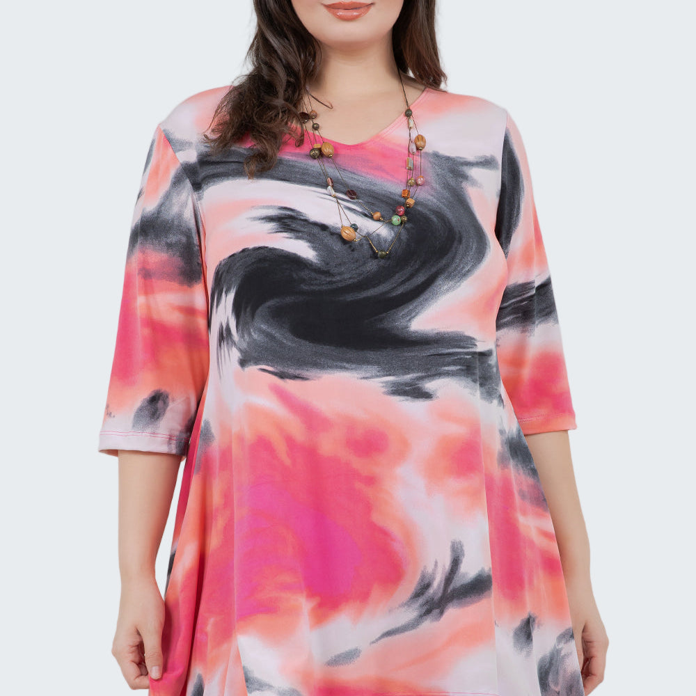 Woman wearing a colorful tie-dye shirt against a white background