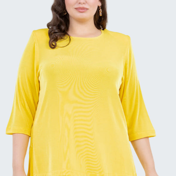 Woman wearing a yellow outfit with a plain background