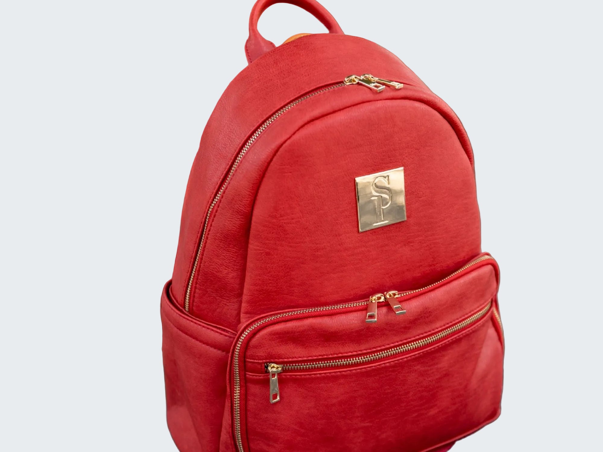 Red backpack with gold accents on a red background