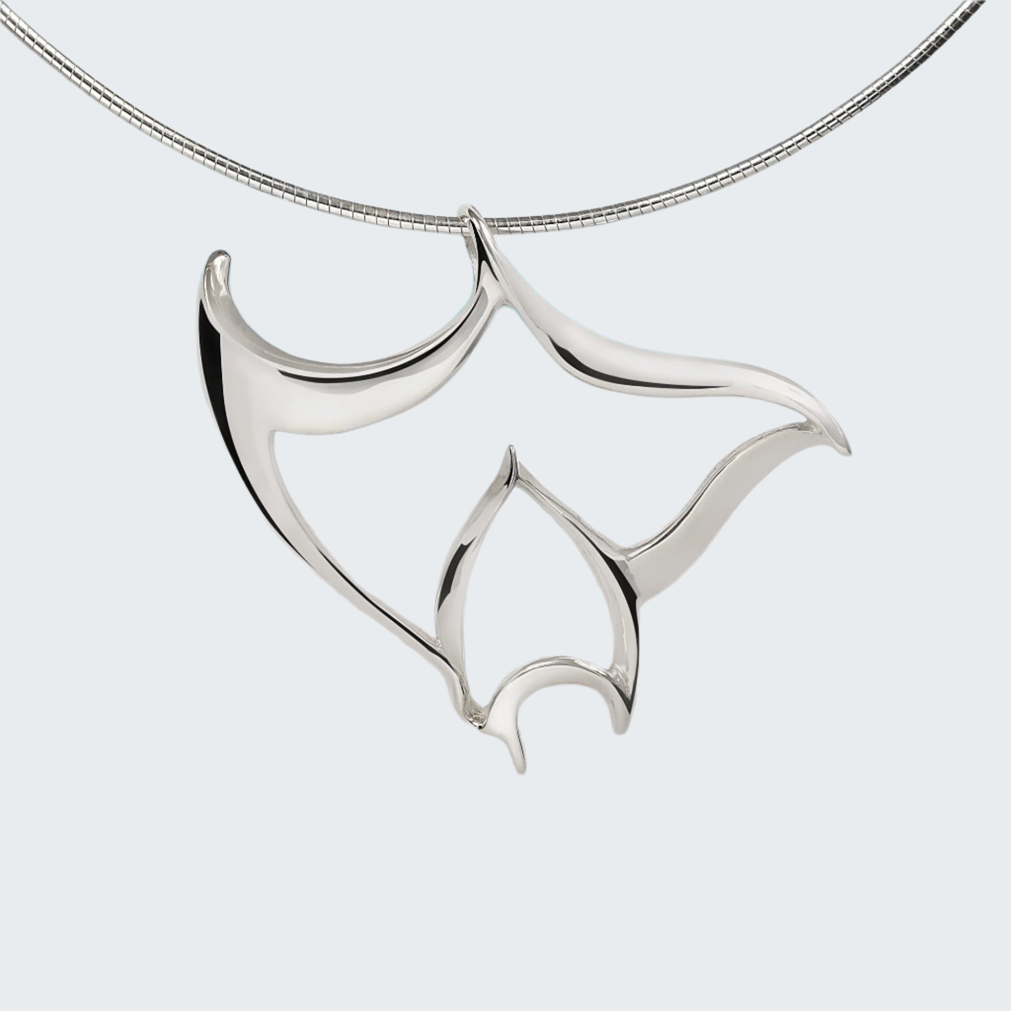 Silver necklace with a leaf-shaped pendant on a wooden surface with a beach background
