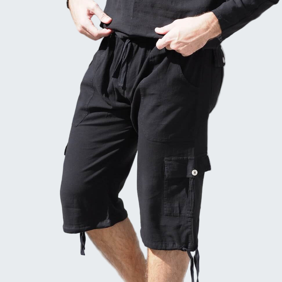 Person wearing black cargo shorts and a black long-sleeve shirt on a crosswalk.