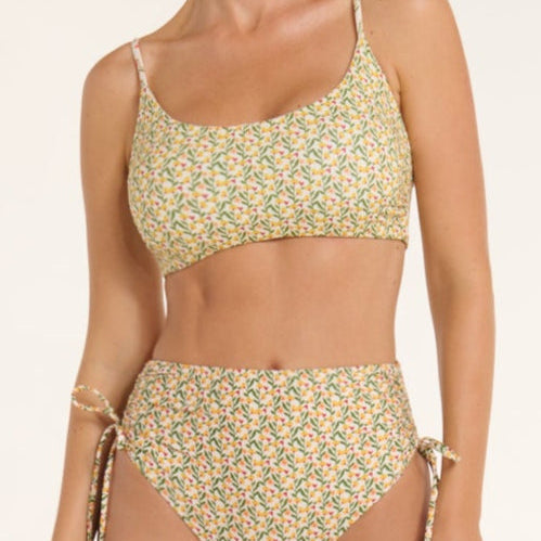 Woman wearing a floral two-piece swimsuit on a white background