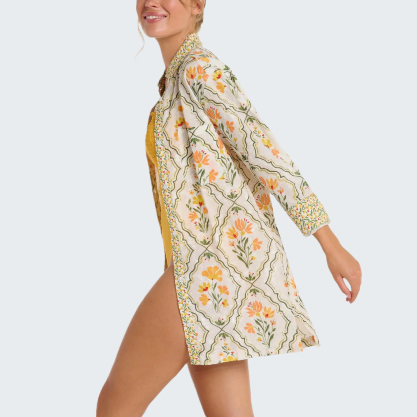 Woman wearing a floral kimono-style garment on a plain background